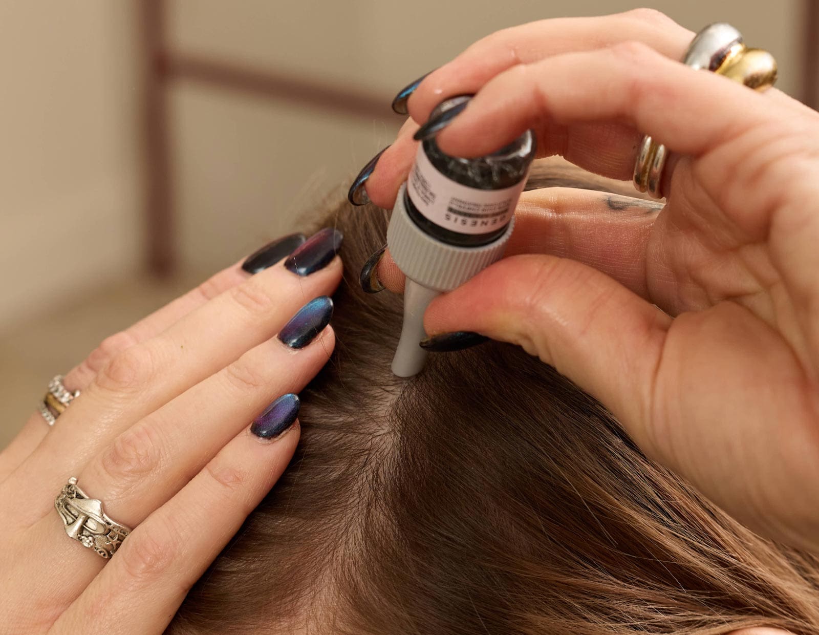Image of An image of Nicole applying a scalp serum
