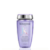 Kérastase Paris Blon Absolu Bain Lumère shampoo bottle in a translucent light purple color with a metallic silver cap, shown on a white background with a soft reflection.