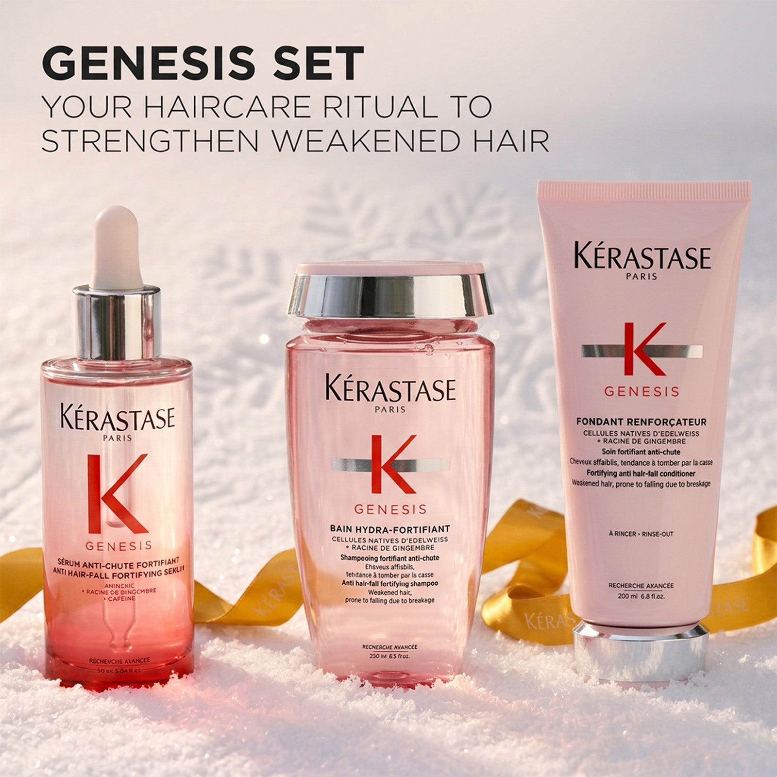 Image of Three Kérastase Paris Genesis haircare products arranged in white snow-like texture with gold leaves: a pink serum bottle with dropper, a pink shampoo bottle with silver cap, and a pink conditioner. Large text at top reads 'GENESIS SET'.