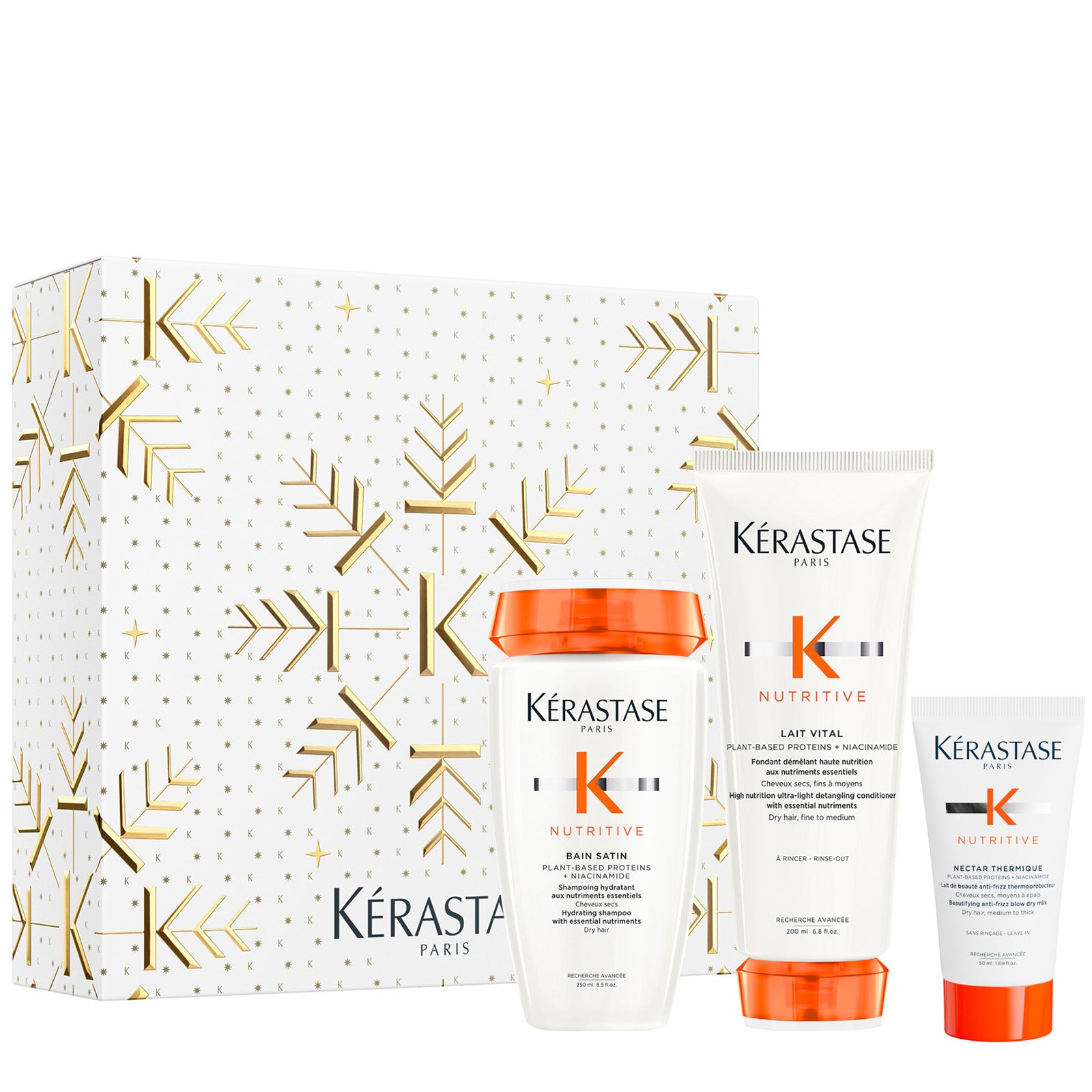 Image of Kérastase Paris Nutritive hair care gift set featuring a white box with gold patterns, a bottle of Bain Satin Riche shampoo, a tube of Lait Vital conditioner, and a tube of Nectar Thermique blow dry cream, arranged on a white background.