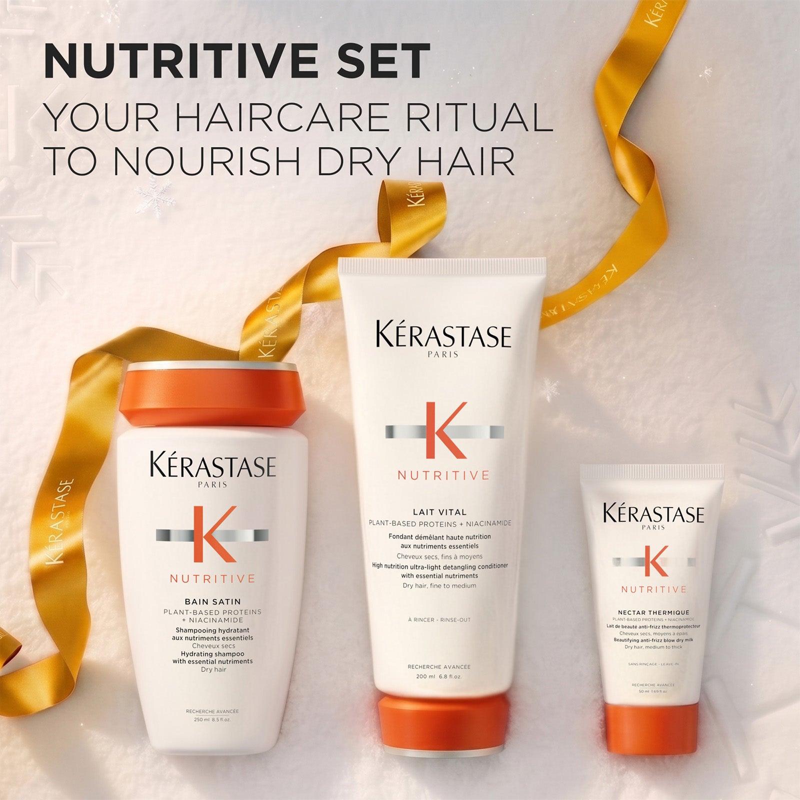 Image of Three Kérastase Paris Nutritive haircare products arranged on a light textured background with a gold ribbon: a Bain Satin shampoo bottle, a Lait Vital conditioner tube, and a Nectar Thermique Blow Dry Cream Tube. Large text at the top reads 'NUTRITIVE SET' and 'YOUR HAIRCARE RITUAL TO NOURISH DRY HAIR '.