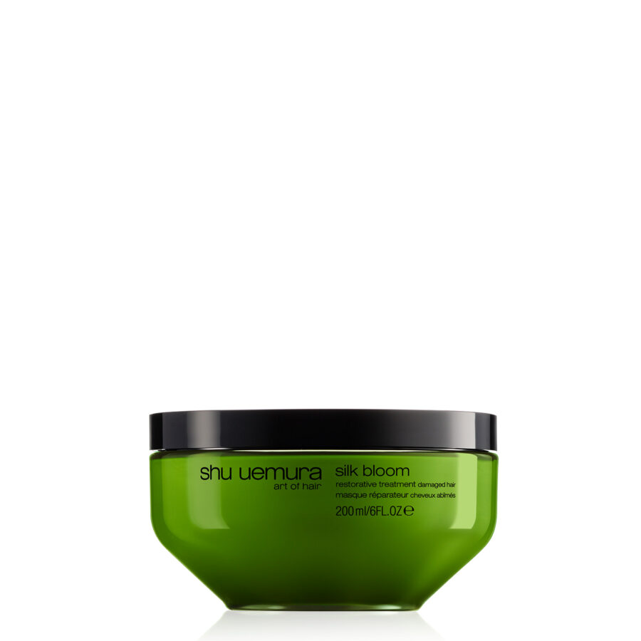 A container of shu uemura silk bloom restorative treatment for hair on a white background.