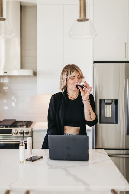 Nicole in kitchen sipping wine with Pomme Diffuser