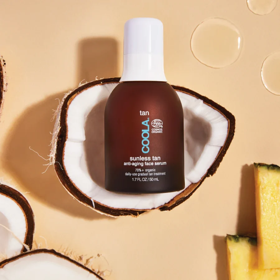 an image of the coola sunless tan face serum bottle on half of a coconut.