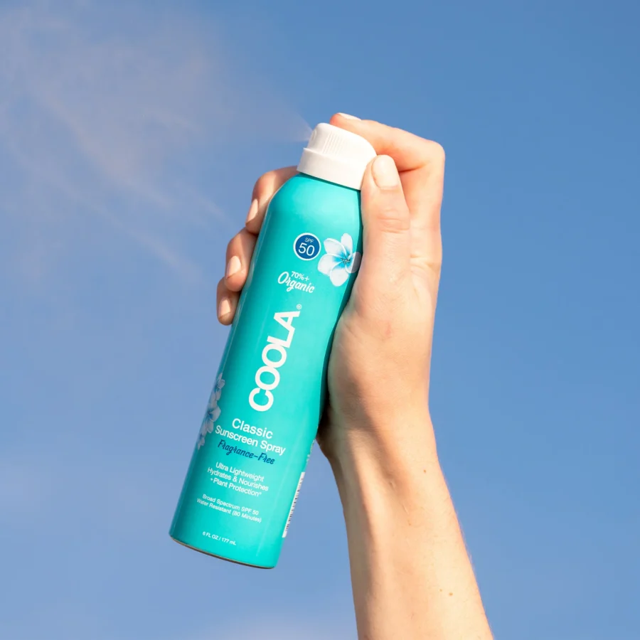 an image of the coola fragrance free sunscreen on a blue background.