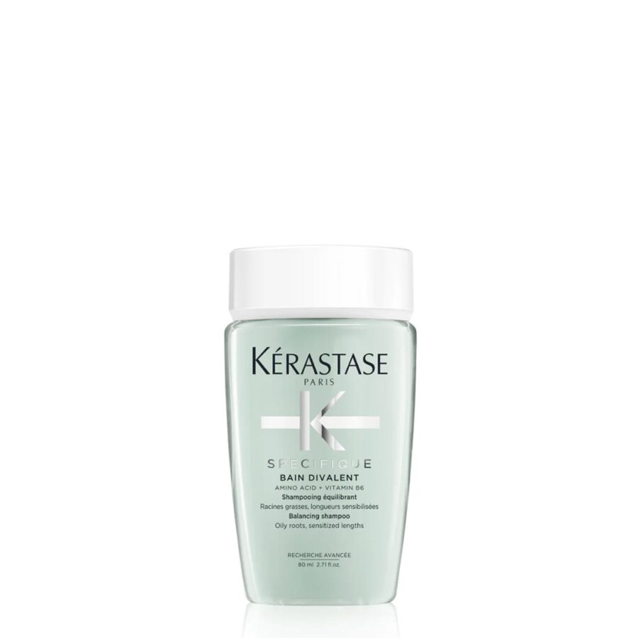 A bottle of kérastase specifique bain divalent shampoo on a white background.